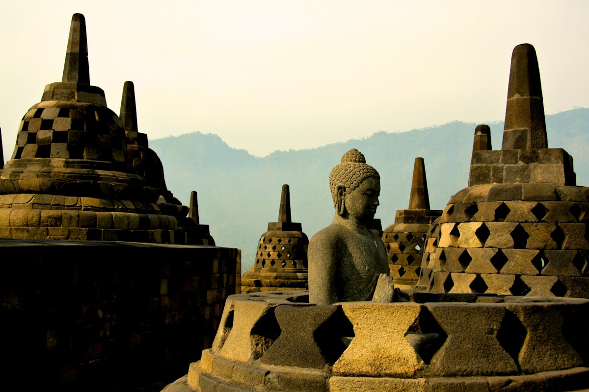 Buddha statue inside a stone stupa at Borobudur temple, Java, Indonesia