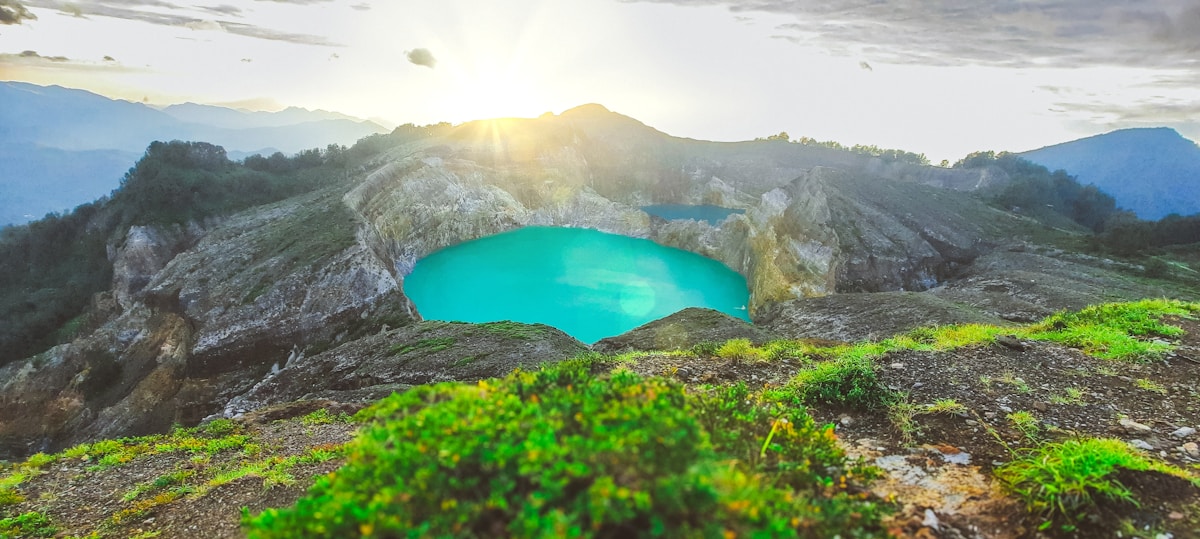 Turquoise volcanic crater lake glowing at sunrise, Kelimutu, Flores, Indonesia