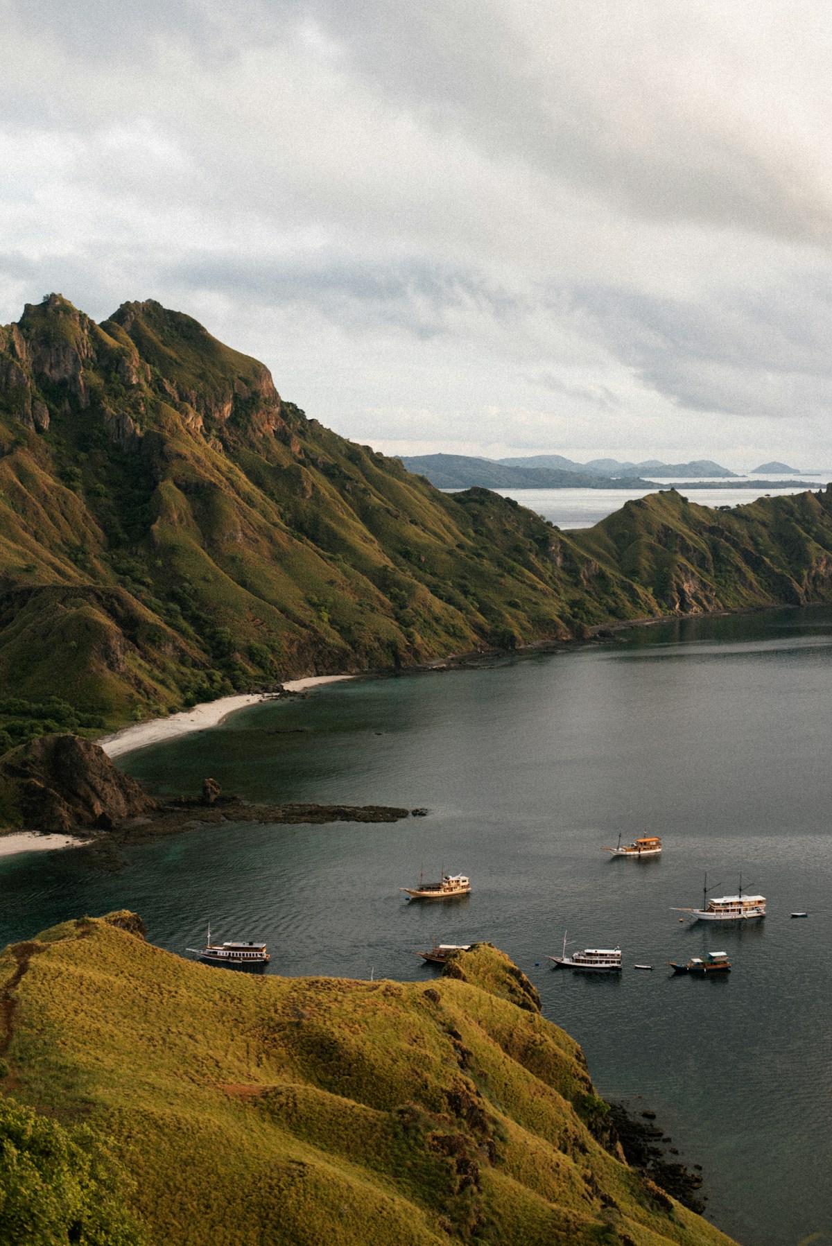 Liveaboard boats anchored in a sheltered bay at Padar Island, Komodo National Park, Indonesia