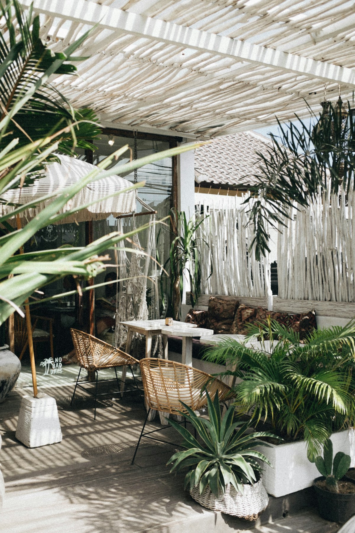 White rattan table with wicker chair beside tropical plants, Canggu, Bali, Indonesia