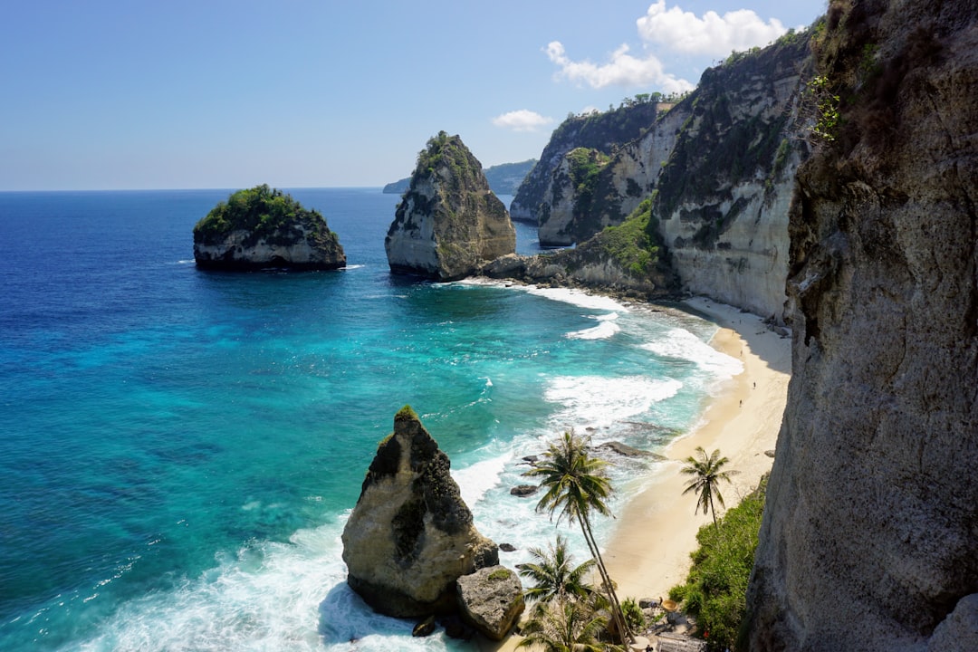 Secluded cove beach with turquoise water and white sand framed by limestone cliffs, Bali, Indonesia