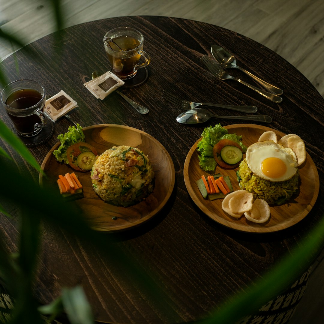 Nasi goreng with fried egg, prawn crackers and vegetables on wooden plates, Bali, Indonesia