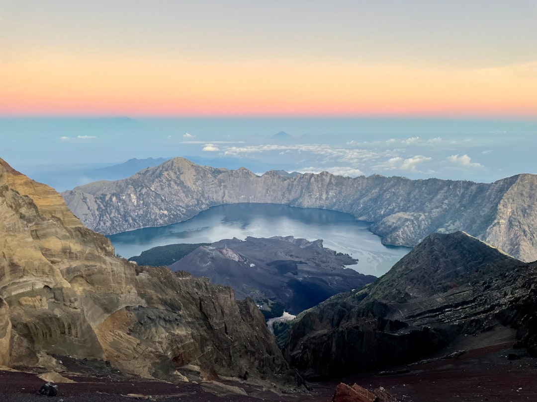Segara Anak crater lake viewed from the rim of Mount Rinjani with Gunung Barujari rising from the mist, Lombok, Indonesia