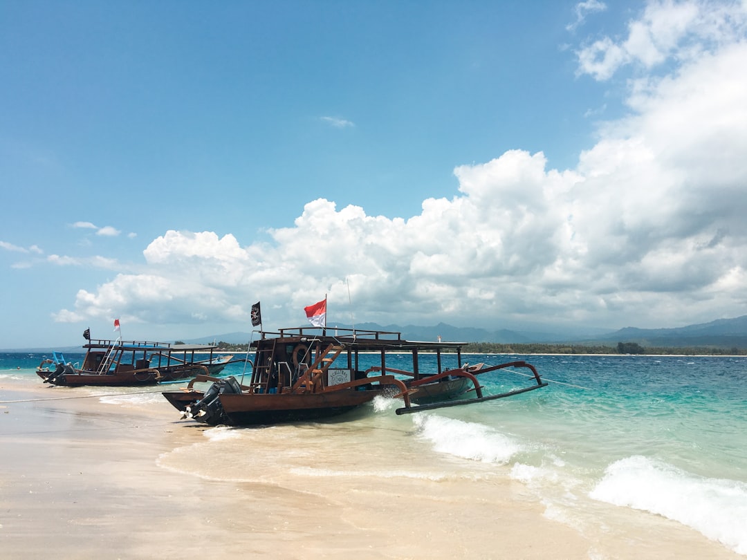 Traditional wooden outrigger boats on the beach with Indonesian flags, Gili Trawangan, Lombok, Indonesia