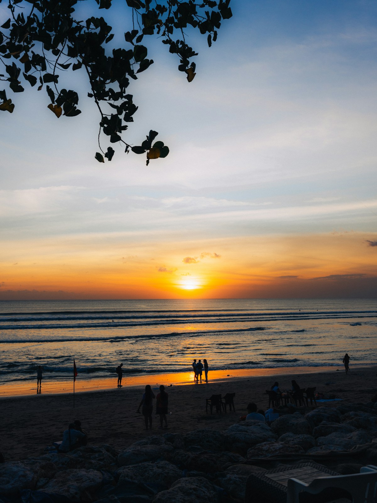 People watching sunset on a tropical beach, Seminyak, Bali, Indonesia