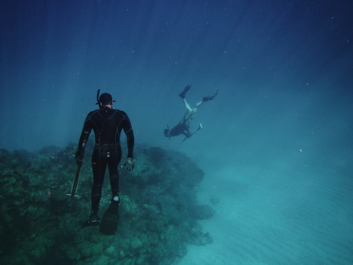 Two freedivers exploring coral reef in clear turquoise water, Togean Islands, Sulawesi, Indonesia
