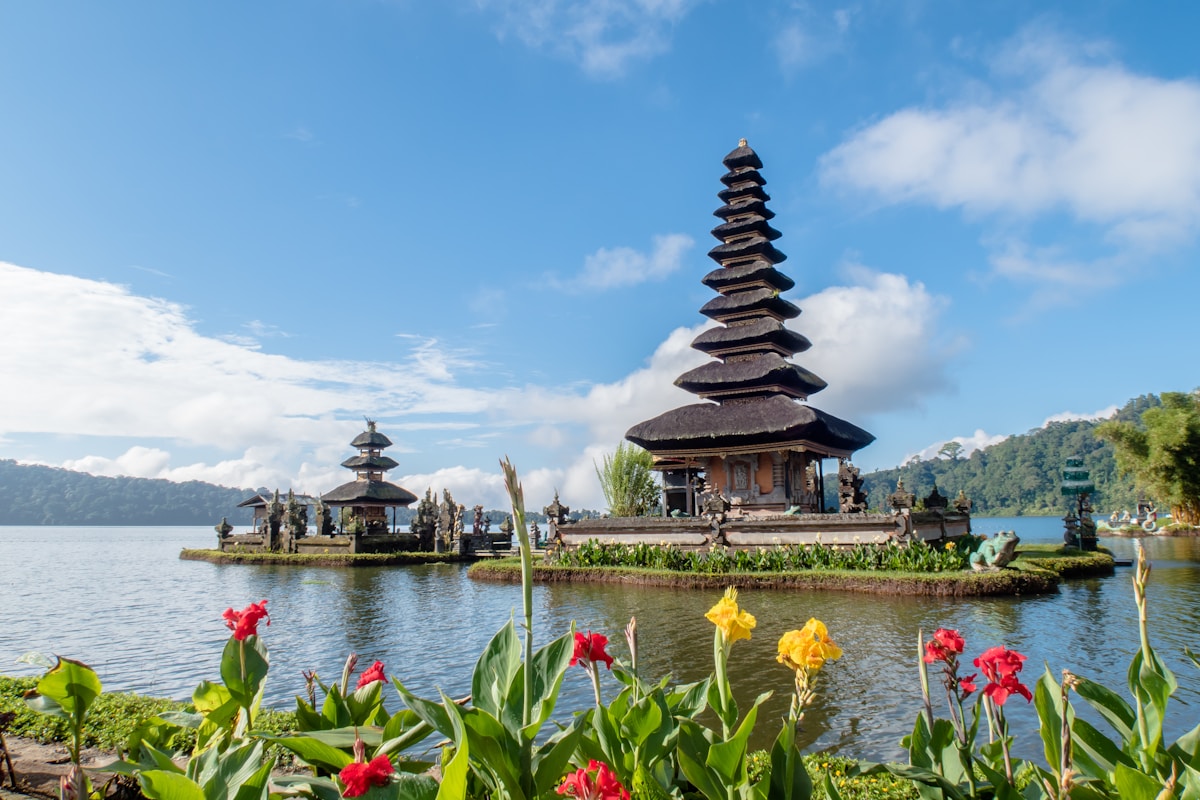 Pura Ulun Danu Bratan lake temple with flowers in the foreground, Bali