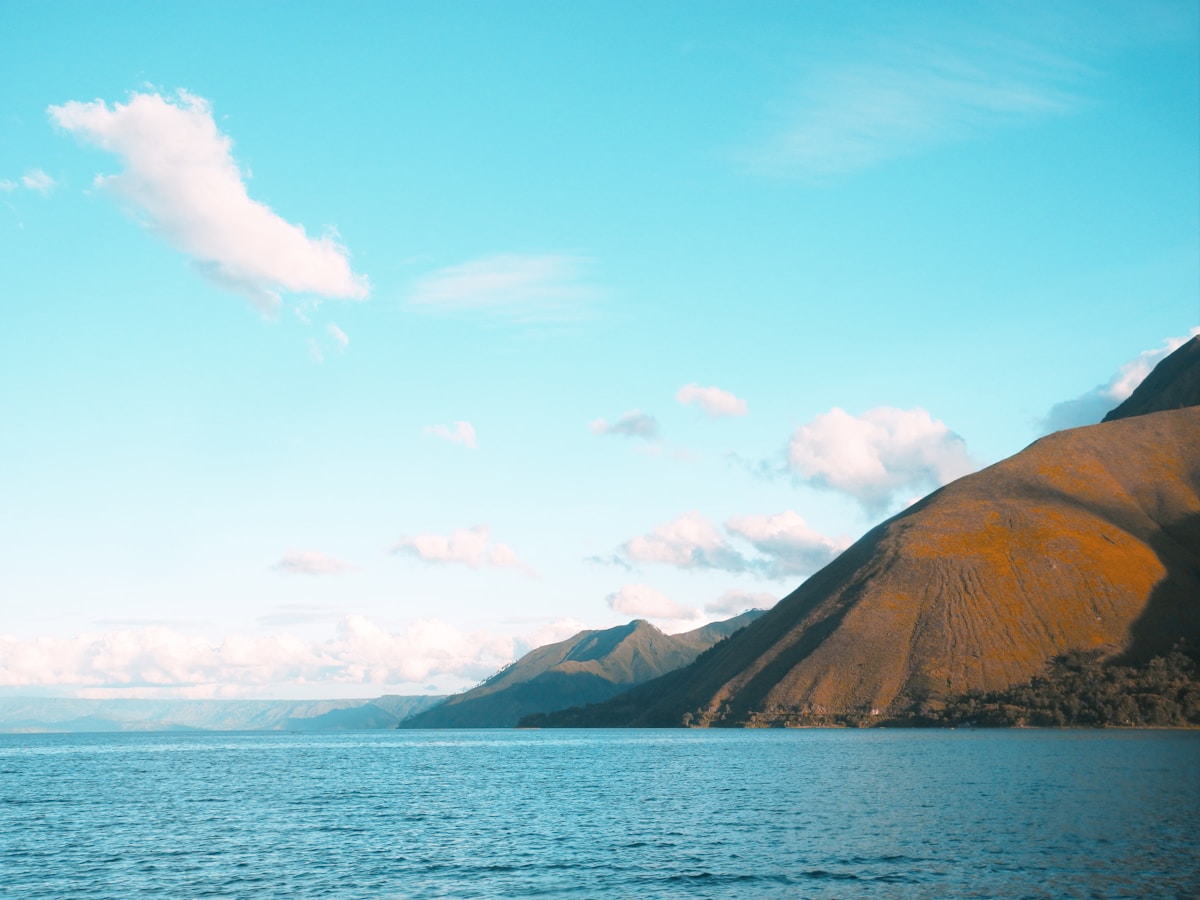 Calm lake surrounded by green mountains, Lake Toba, North Sumatra, Indonesia