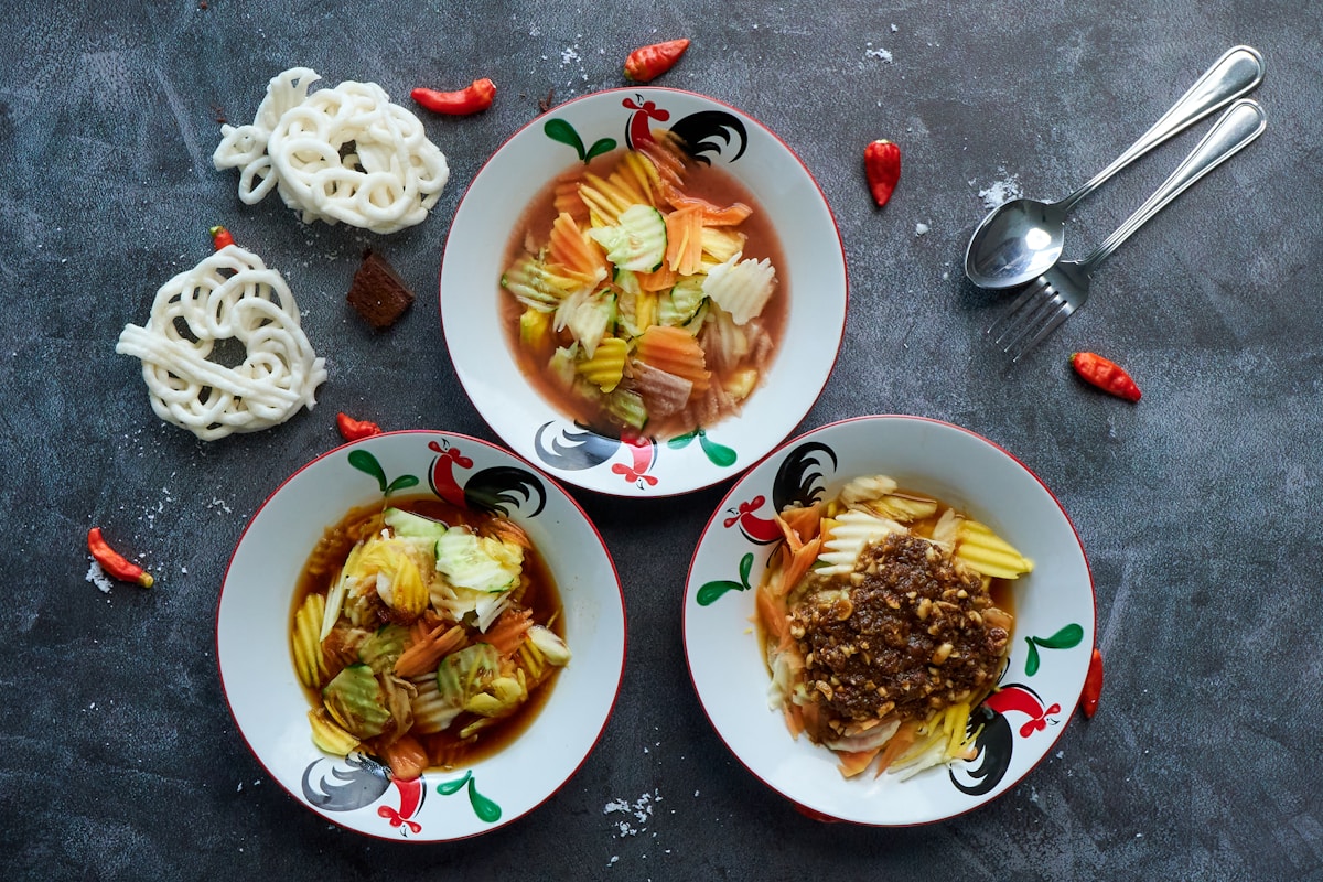 Three bowls of food with spoons, Indonesian food spread