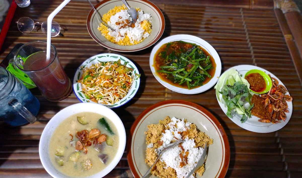 Table topped with plates of food and soup bowls, Makassar, Indonesia