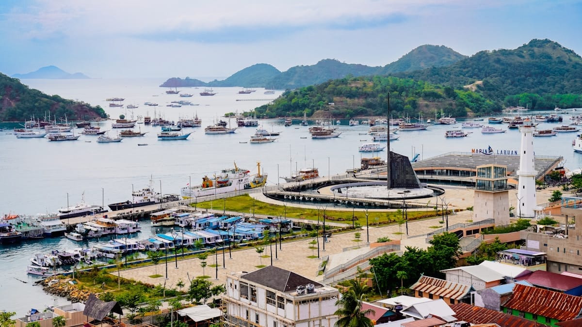 Boats docked in bay with lush green hills, Makassar, Indonesia