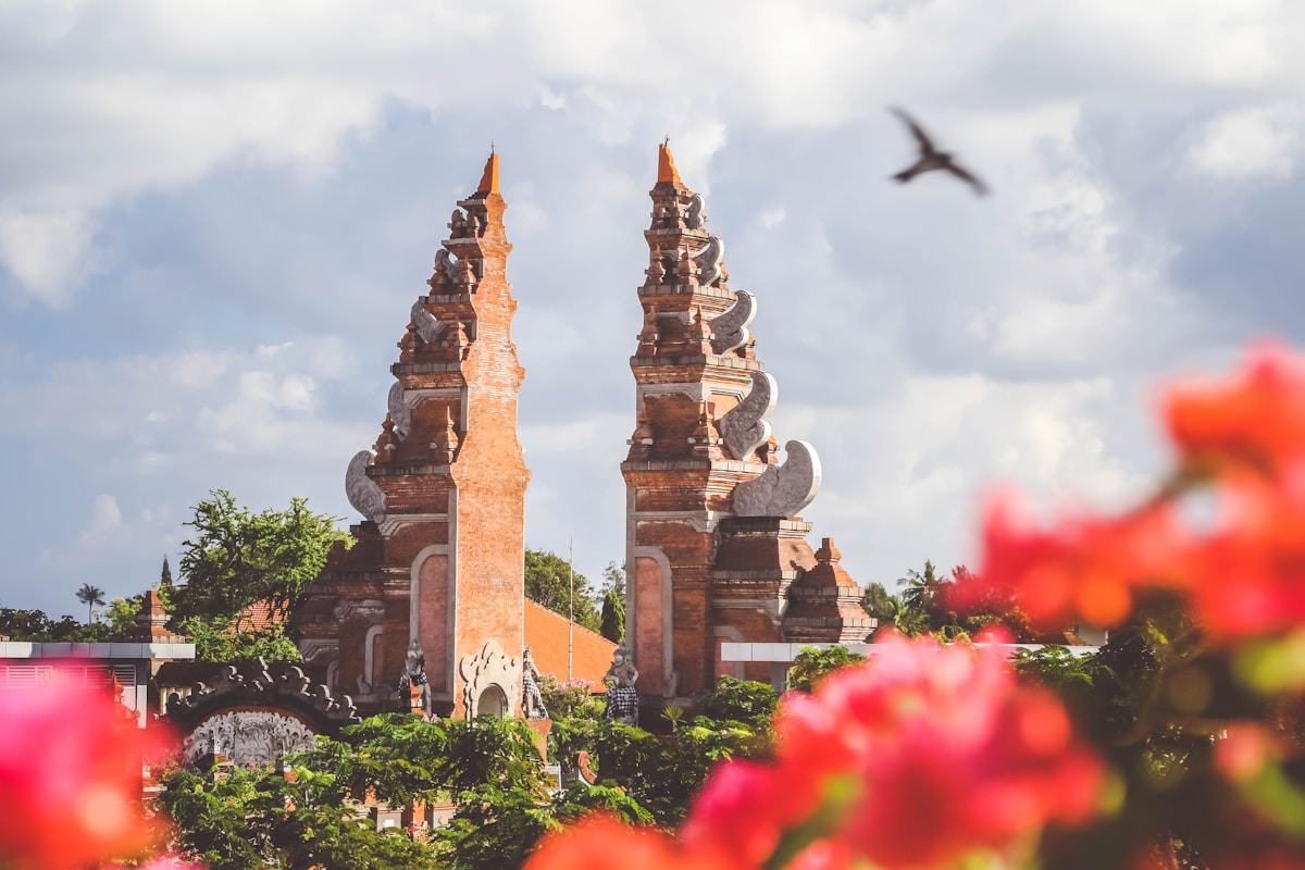 Bird flying over brown concrete gate, Bali, Indonesia