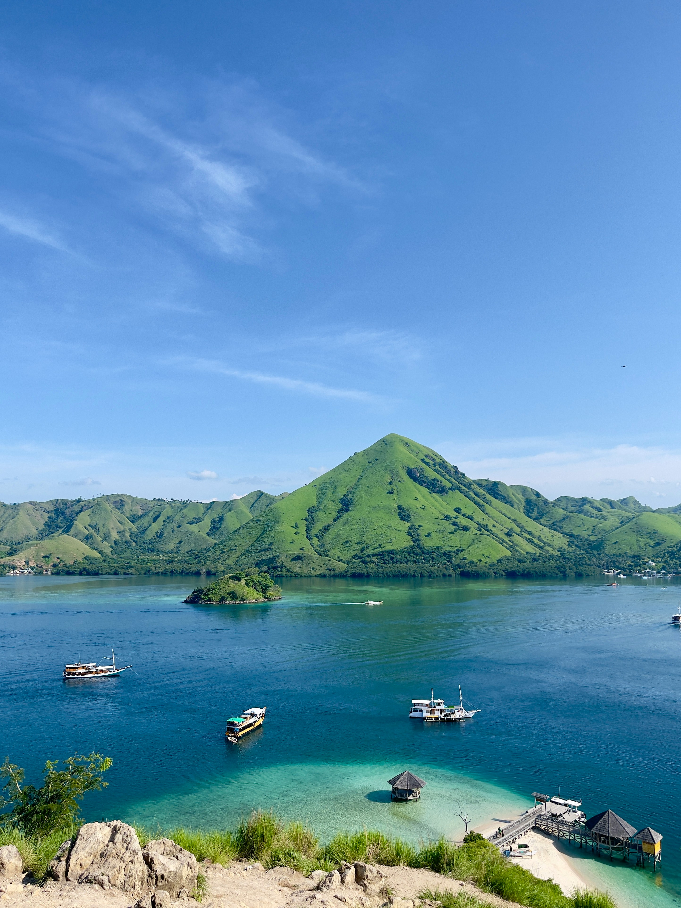 Turquoise bay with liveaboard boats and green mountains near Labuan Bajo, Flores, Indonesia