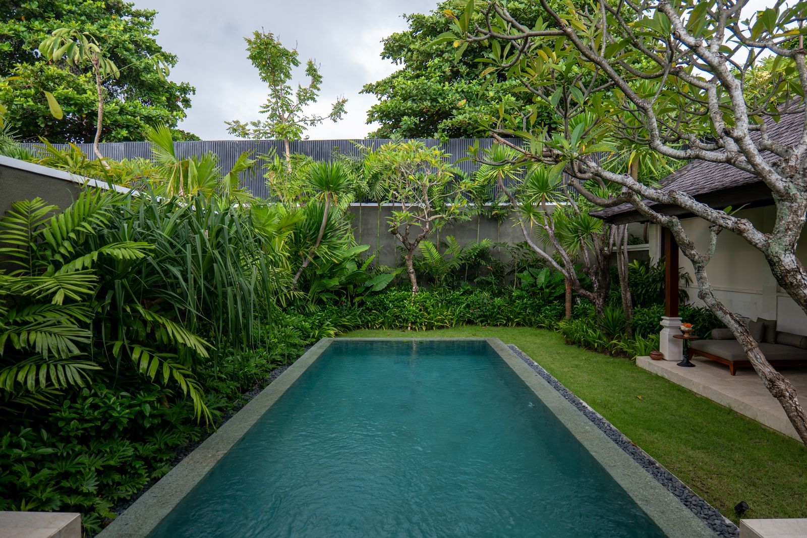 Private villa pool surrounded by lush tropical garden, Bali, Indonesia