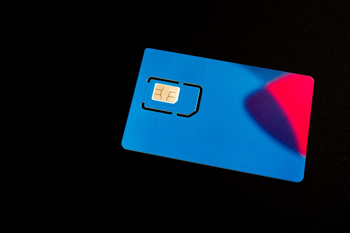 A blue SIM card sits on a dark surface
