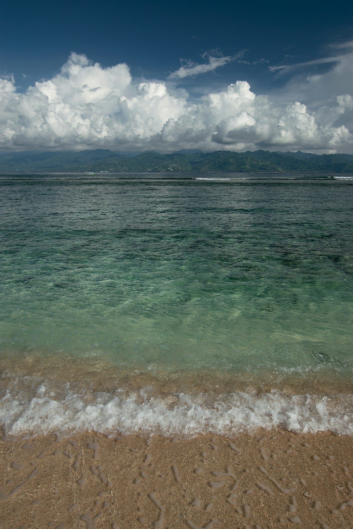 Sandy beach with clear turquoise ocean and distant mountains, Sanur, Bali, Indonesia