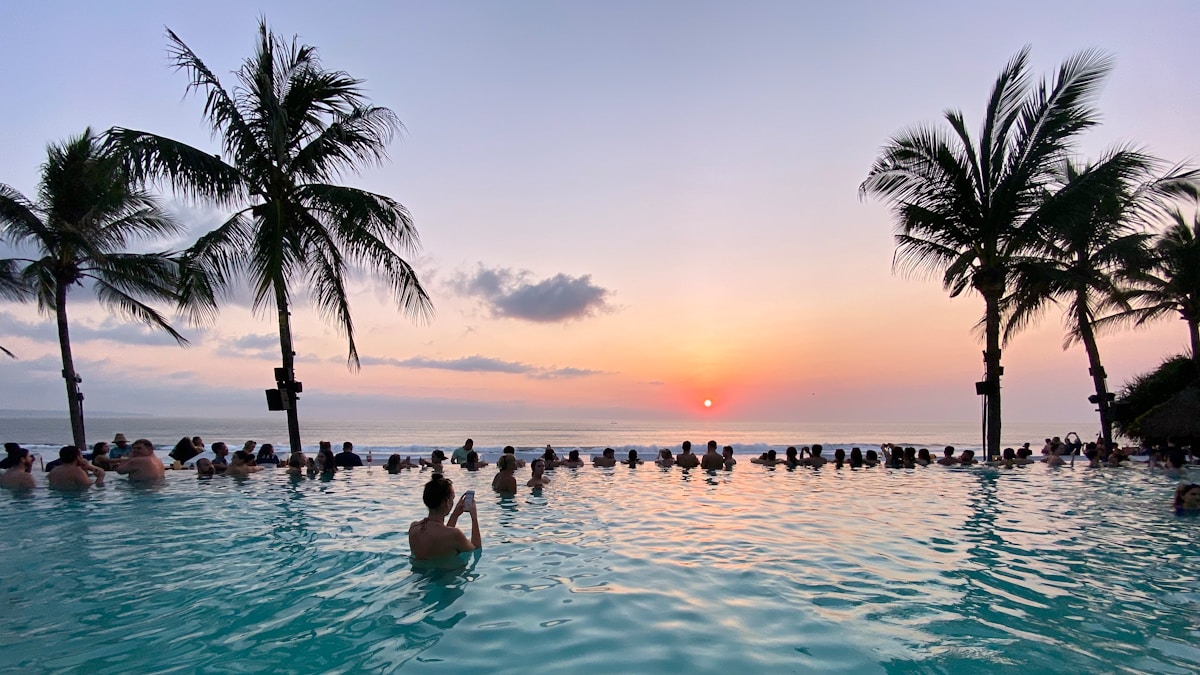 Rooftop pool at a Seminyak hotel overlooking palm trees and the Bali coastline