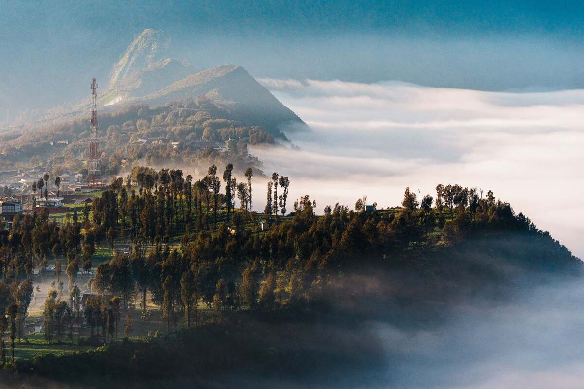 Mount Bromo rising above morning cloud and the highland village, East Java, Indonesia