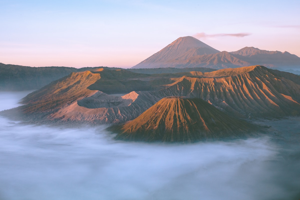 Coloured sulphurous crater lake surrounded by highland landscape at Dieng Plateau, Java