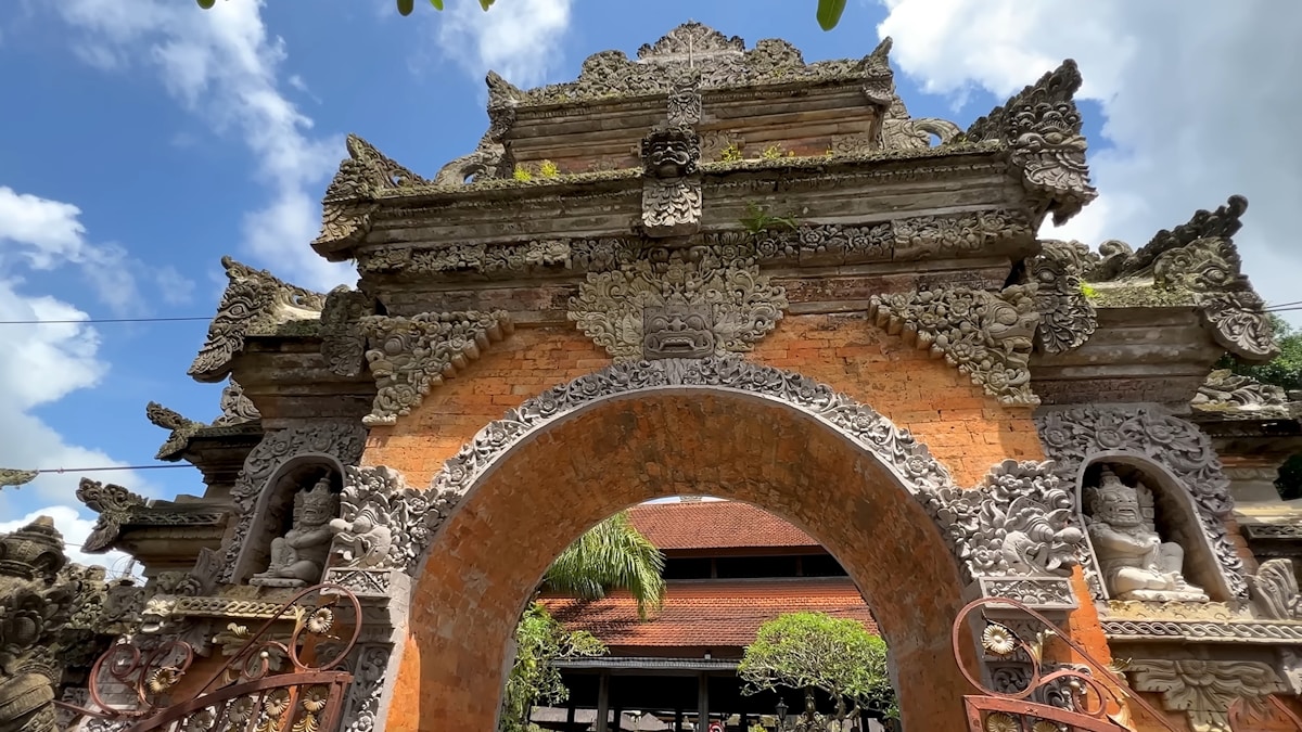 Stone archway with carved statues at a temple entrance, Ubud, Bali, Indonesia