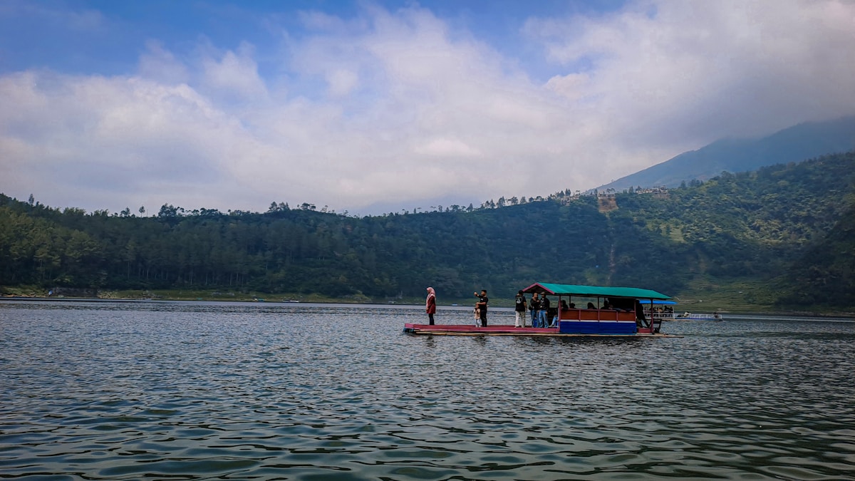 Boat on Telaga Menjer lake with forested highlands, Wonosobo, Central Java, Indonesia