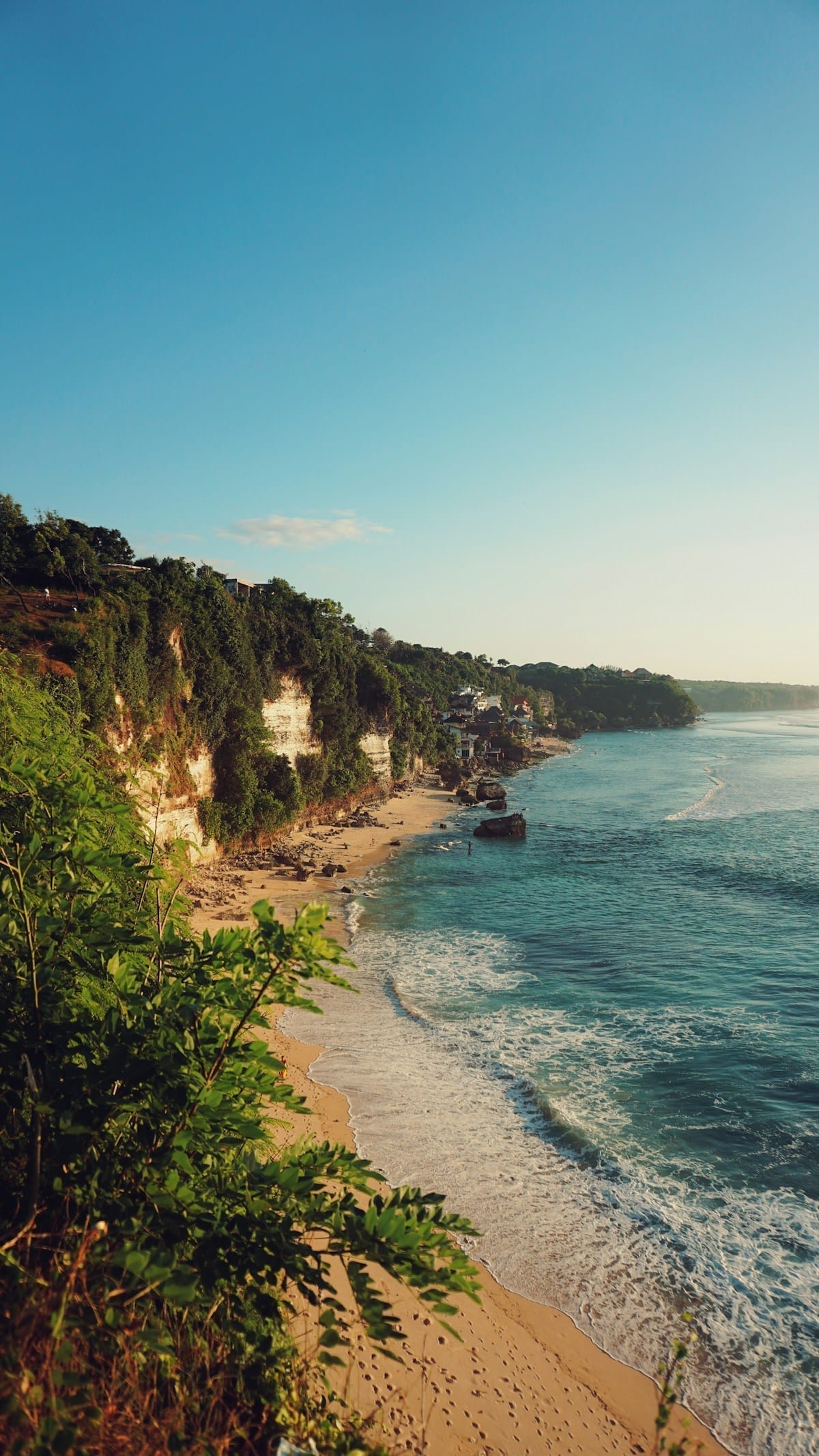 Limestone cliffs and sandy beach at Jimbaran Bay, Bali, Indonesia