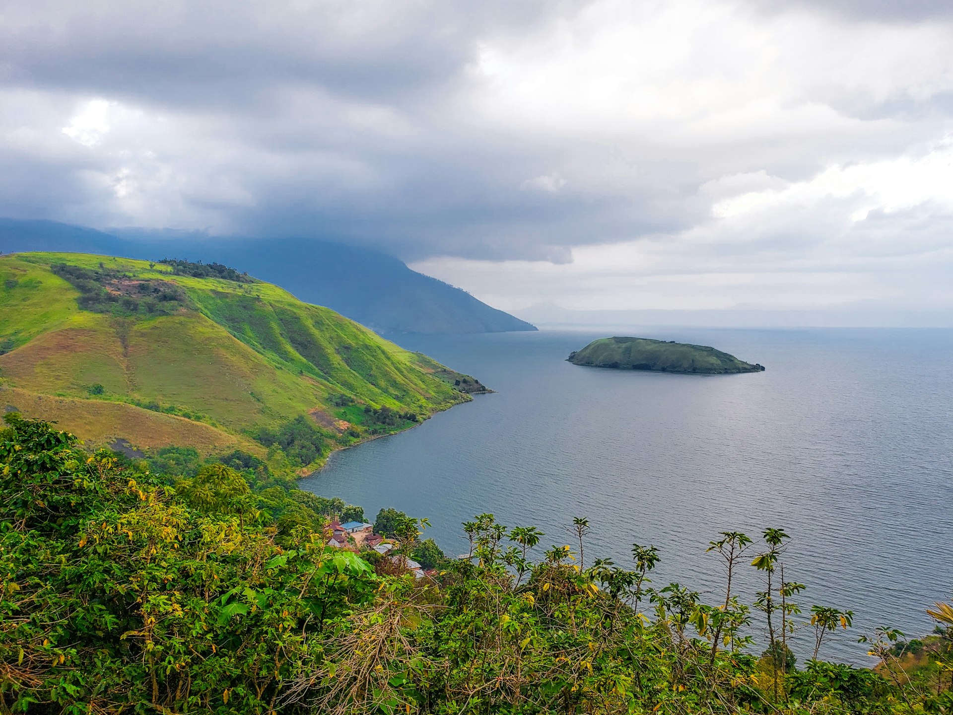 Lake Toba caldera with green hillsides and small island, Sumatra, Indonesia