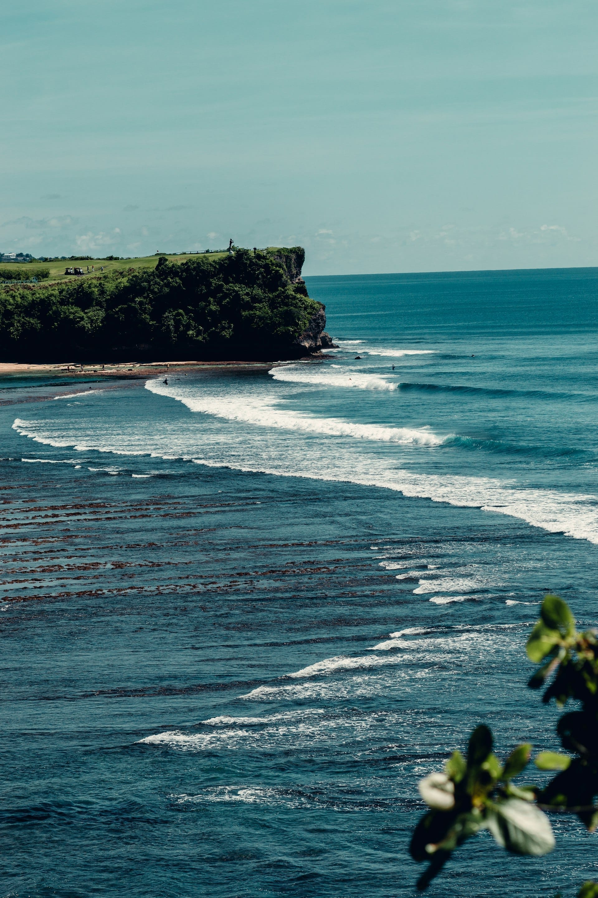 Bali coastline with rolling waves and green headland, Indonesia