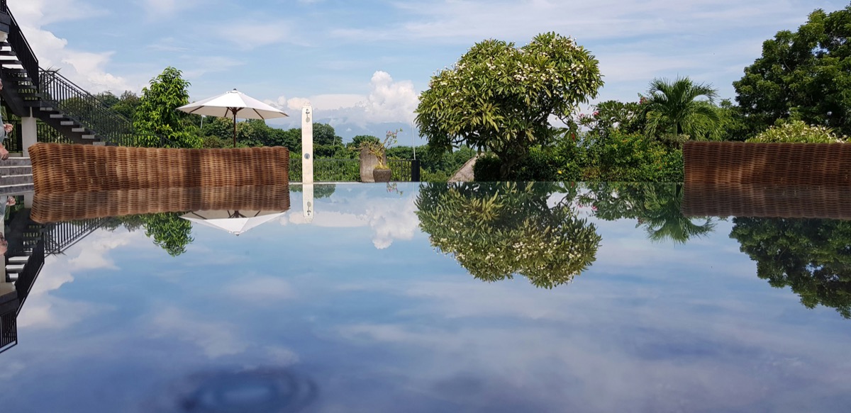 Rice paddies and traditional Balinese village in Canggu, with surfboards leaning against a cafe wall
