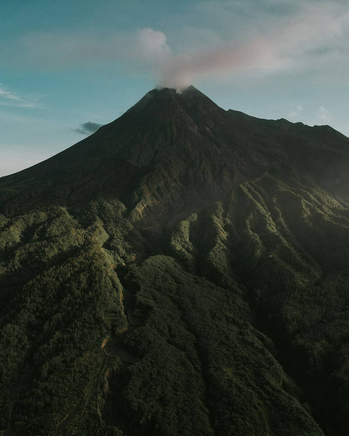 Mount Merapi volcano with smoke rising from crater, viewed from Yogyakarta, Java, Indonesia